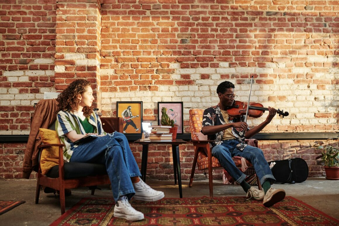 Young woman looking at her African American boyfriend playing violin